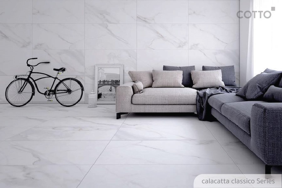 A white marble floor with a couch and a bicycleDescription automatically generated